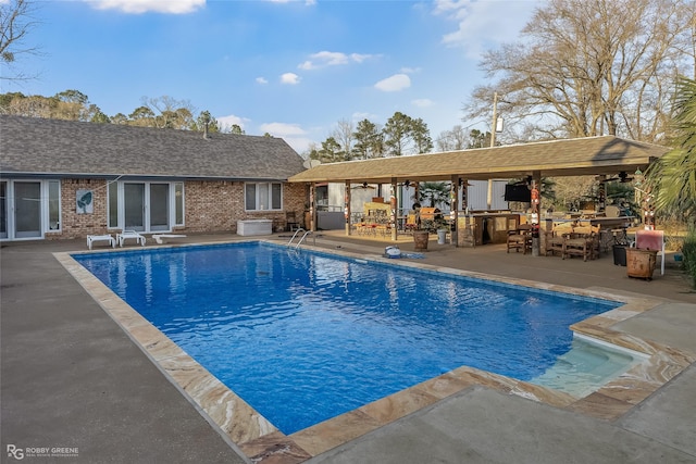 view of pool featuring a patio, an outdoor bar, and area for grilling