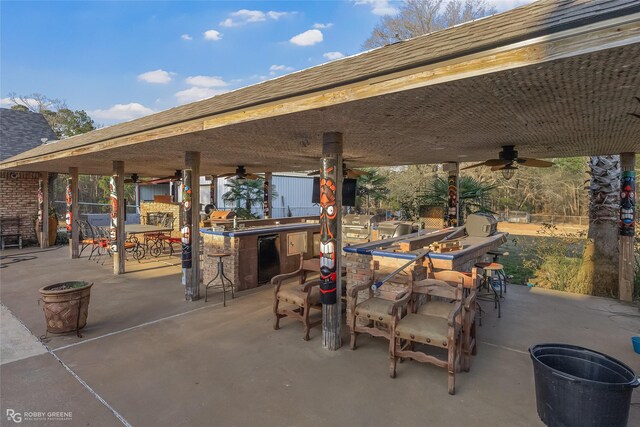 view of patio / terrace with ceiling fan and a bar