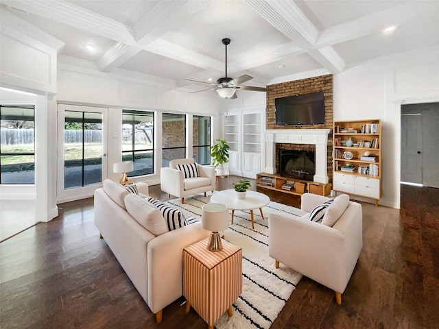 living area with a brick fireplace, coffered ceiling, dark wood finished floors, and beamed ceiling