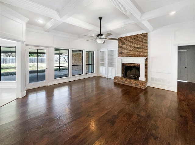 unfurnished living room with built in features, beam ceiling, a fireplace, and dark wood-style floors