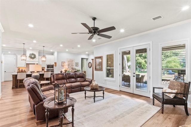 living room featuring light wood-type flooring, french doors, and ornamental molding