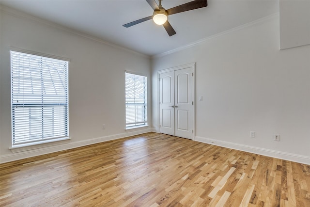 empty room featuring ceiling fan, ornamental molding, and light wood-type flooring