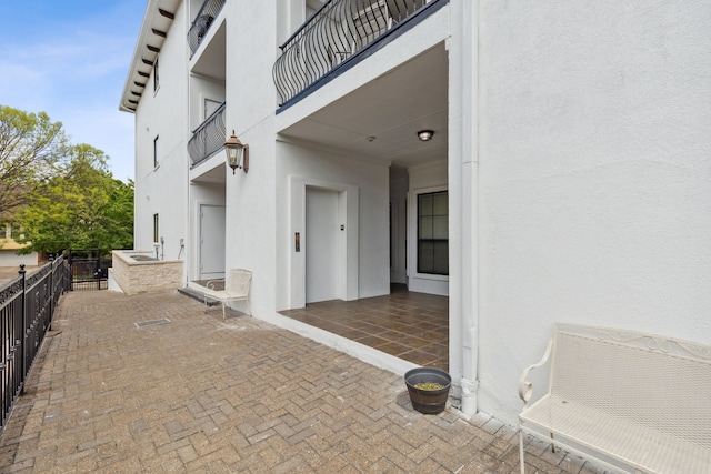 view of patio / terrace with elevator and a balcony