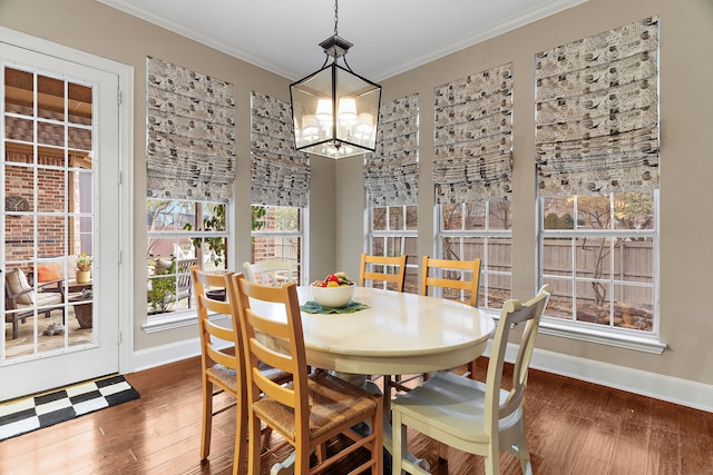 dining space with ornamental molding, dark hardwood / wood-style floors, and an inviting chandelier