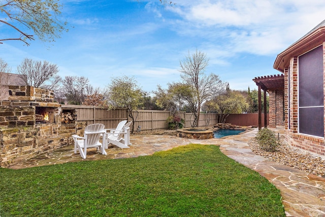 view of yard with an outdoor stone fireplace, an in ground hot tub, and a patio area