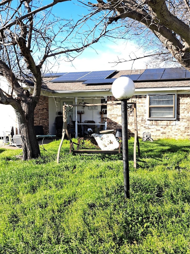 view of side of home featuring solar panels and a lawn