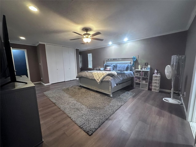 bedroom featuring ceiling fan, a closet, crown molding, and dark hardwood / wood-style floors