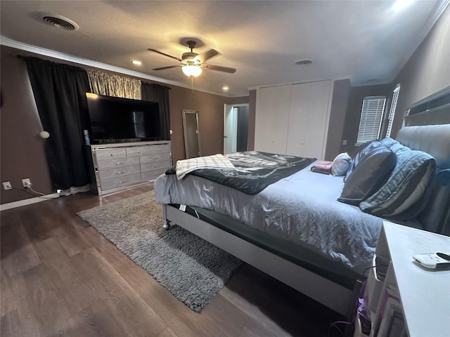 bedroom featuring ceiling fan, a closet, dark hardwood / wood-style flooring, and ornamental molding