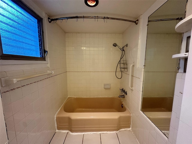 bathroom featuring tile patterned flooring, tile walls, and tiled shower / bath