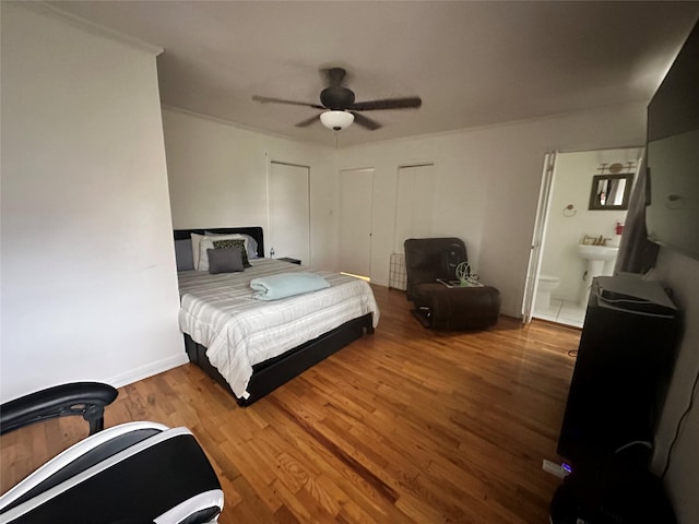 bedroom featuring ensuite bathroom, ceiling fan, and wood-type flooring