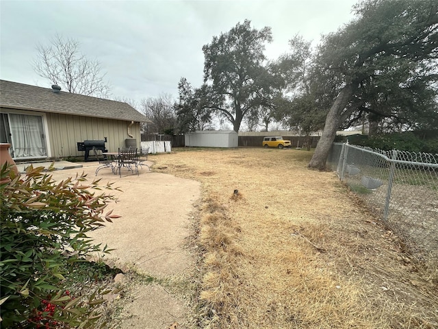 view of yard featuring a shed and a patio area