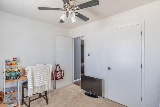 office featuring a ceiling fan and light carpet