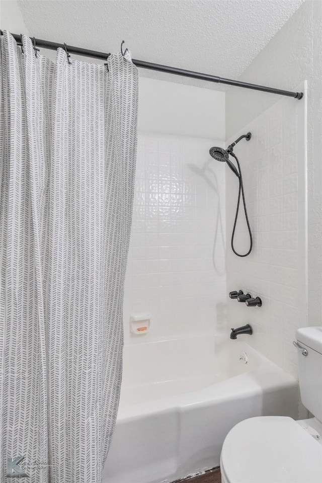 bathroom featuring toilet, shower / bath combo, and a textured ceiling