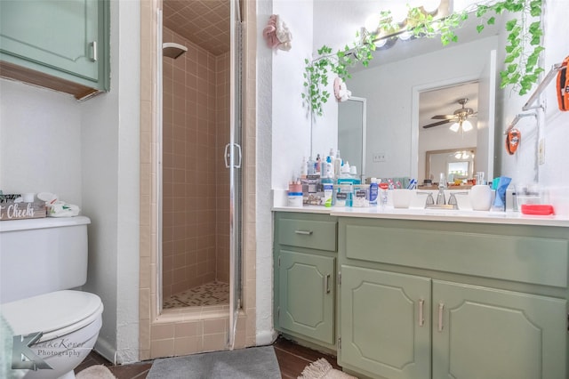 full bathroom featuring a stall shower, vanity, toilet, and a ceiling fan