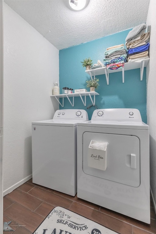 laundry room featuring a textured ceiling, laundry area, baseboards, independent washer and dryer, and wood tiled floor