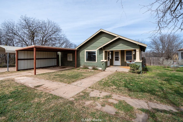 bungalow-style house featuring covered porch, a carport, and a front yard