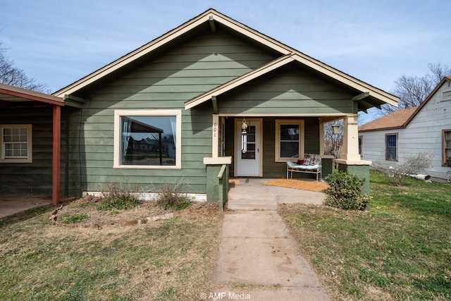 bungalow-style house with covered porch and a front yard