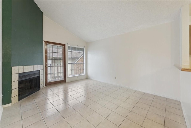 unfurnished living room with a fireplace, high vaulted ceiling, a textured ceiling, and light tile patterned floors