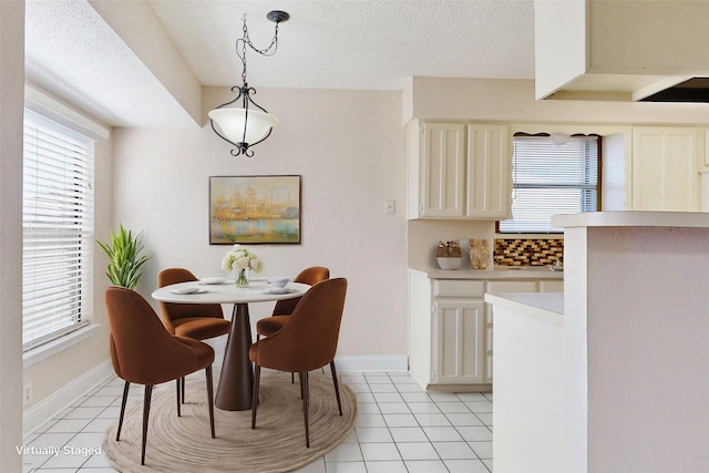 dining room featuring a textured ceiling and light tile patterned floors