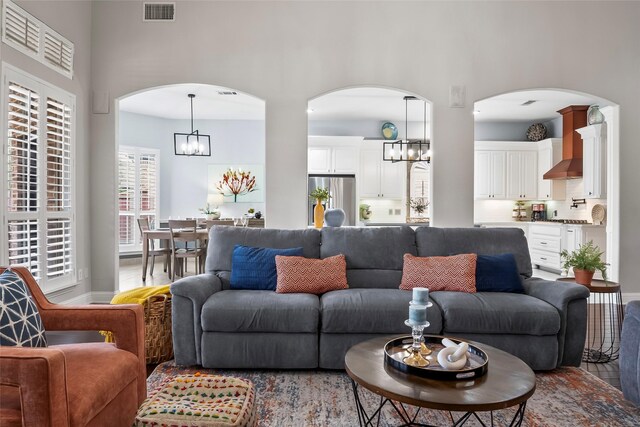 2418 Strathfield Ln, Trophy Club, TX 76262 - living room with a high ceiling, a notable chandelier, arched walkways, and visible vents