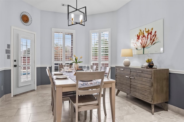 dining room featuring an inviting chandelier, visible vents, baseboards, and light tile patterned floors