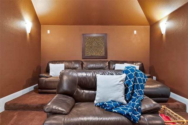 carpeted cinema room with lofted ceiling and baseboards