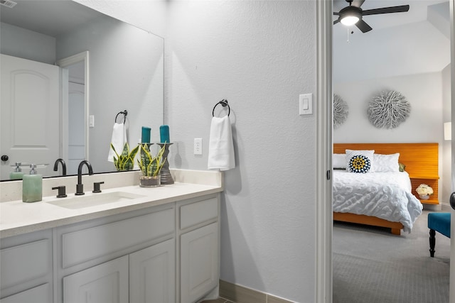 bathroom with visible vents, a textured wall, a ceiling fan, vanity, and ensuite bath