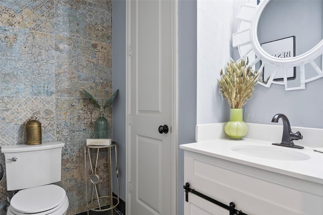 bathroom with toilet, a closet, and vanity