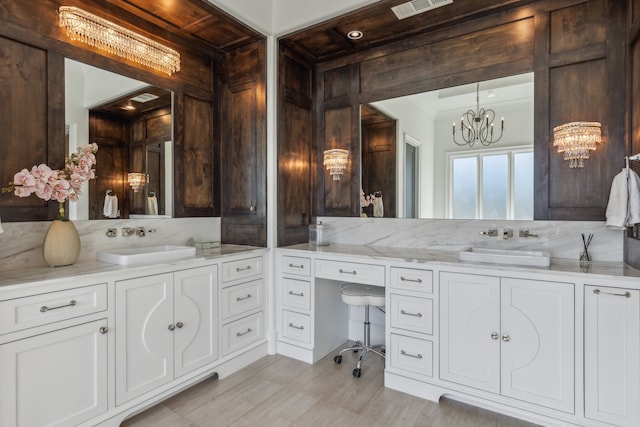 bathroom with vanity, crown molding, and a chandelier