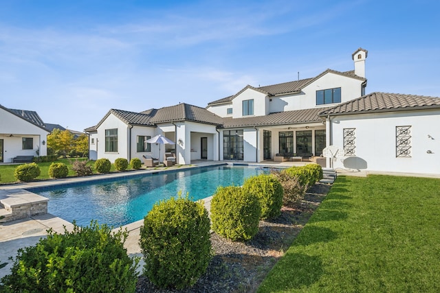 rear view of property featuring a lawn and a patio