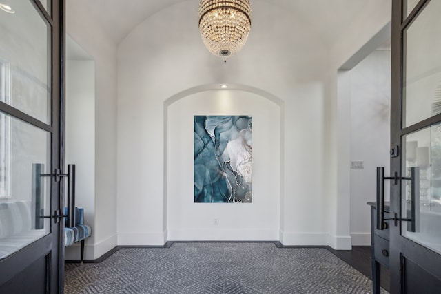 foyer entrance featuring vaulted ceiling and an inviting chandelier