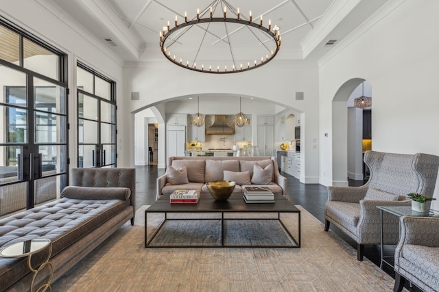 living room with hardwood / wood-style flooring, a high ceiling, and ornamental molding