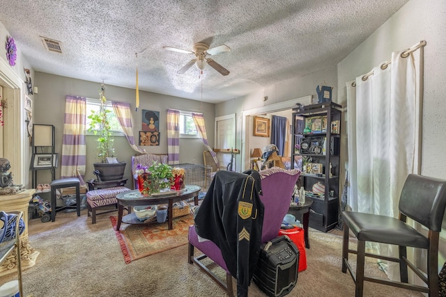 carpeted living room featuring ceiling fan and a textured ceiling