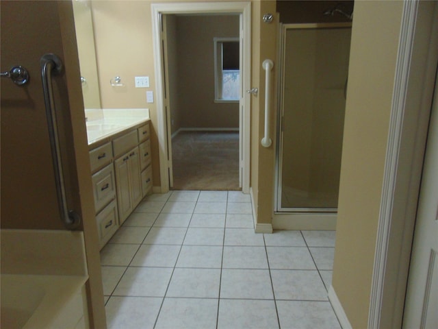 bathroom with tile patterned floors, vanity, and walk in shower