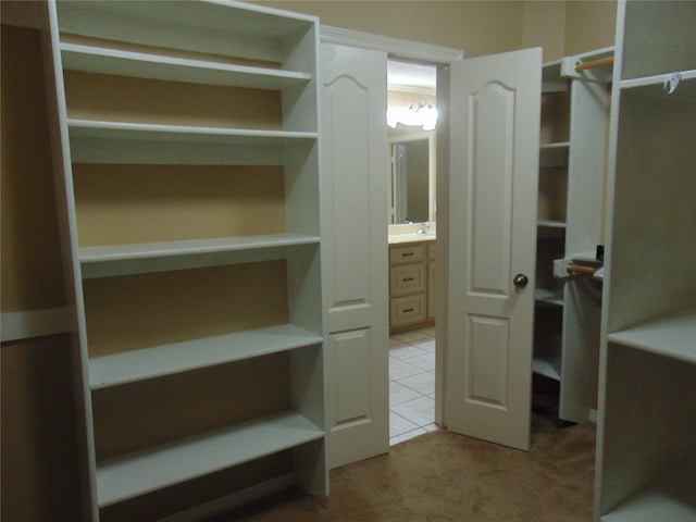 spacious closet featuring light tile patterned flooring and sink