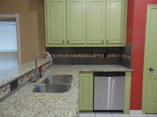 kitchen featuring light tile patterned floors, sink, light stone counters, and stainless steel dishwasher