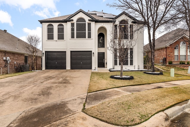 view of front property with a front yard, a garage, solar panels, and central air condition unit