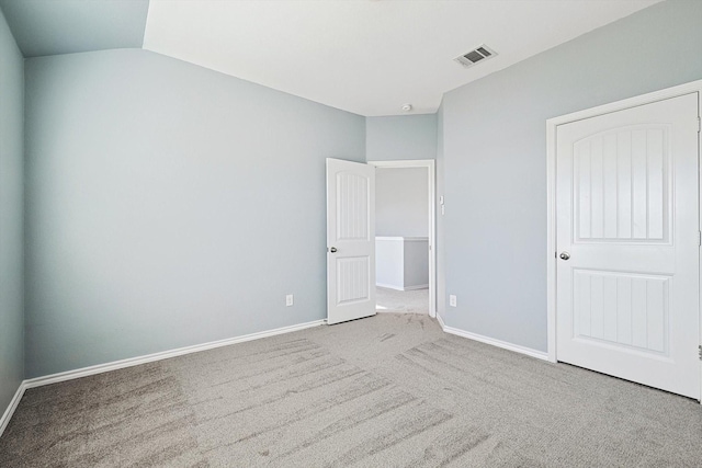 unfurnished bedroom featuring vaulted ceiling and carpet flooring