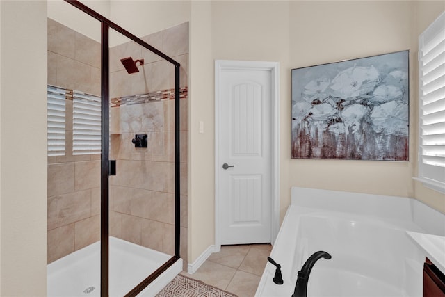 bathroom featuring tile patterned flooring, a bath, and a shower stall