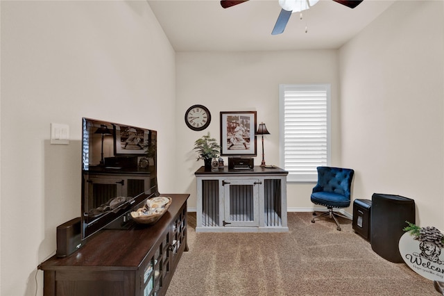 living area featuring a ceiling fan, carpet, and baseboards