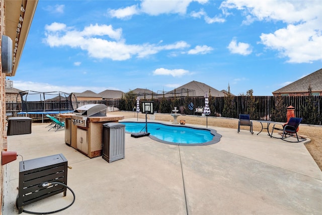 view of swimming pool featuring a fenced in pool, a patio, a fenced backyard, a trampoline, and exterior kitchen