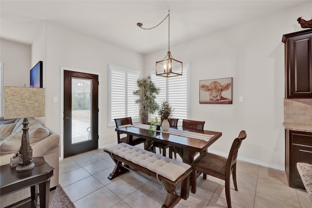 dining area featuring baseboards, a notable chandelier, and light tile patterned flooring