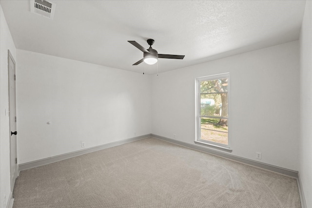 carpeted empty room with ceiling fan and a textured ceiling