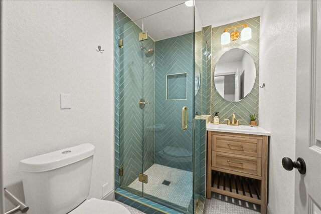 bathroom with vanity, a shower with shower door, and toilet