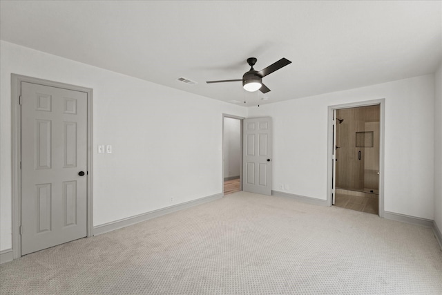 unfurnished bedroom featuring light carpet, connected bathroom, and ceiling fan