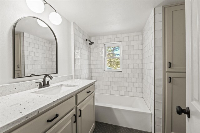 bathroom featuring vanity and tiled shower / bath