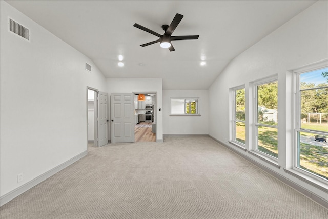 interior space with ceiling fan, vaulted ceiling, and plenty of natural light