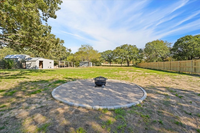 view of yard featuring an outdoor fire pit and a storage shed