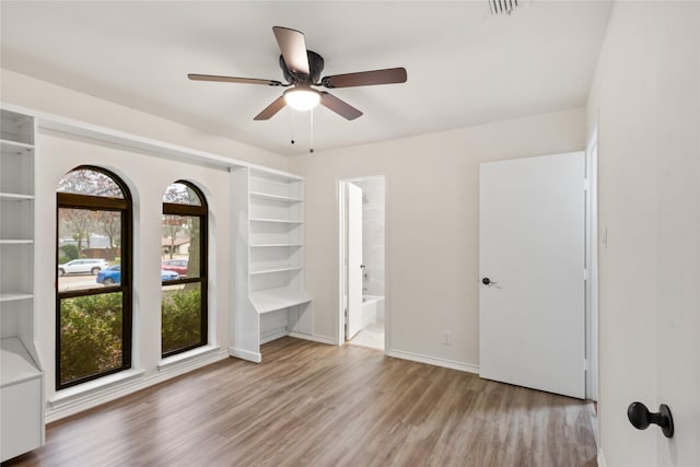 unfurnished bedroom with ceiling fan, light wood-type flooring, and ensuite bathroom