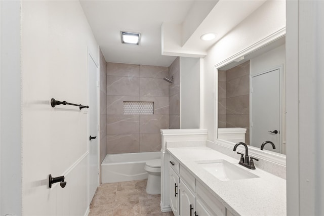 full bathroom featuring tiled shower / bath combo, vanity, and toilet